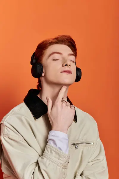 A young and handsome man experiences deep emotion while listening to music, eyes closed. — Stock Photo