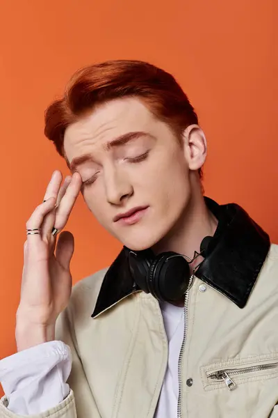 A young, handsome man displays emotion while resting his hand on his forehead, gazing thoughtfully. — Stock Photo