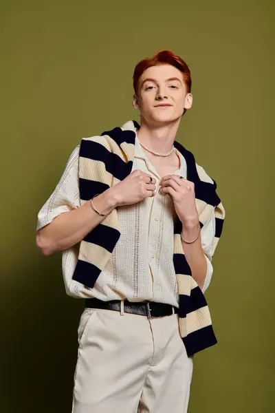 A young man with an emotional expression showcases his fashion sense in a striking setting. — Stock Photo