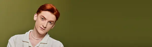 A young handsome man with striking features shows deep emotions against a soft green backdrop — Stock Photo