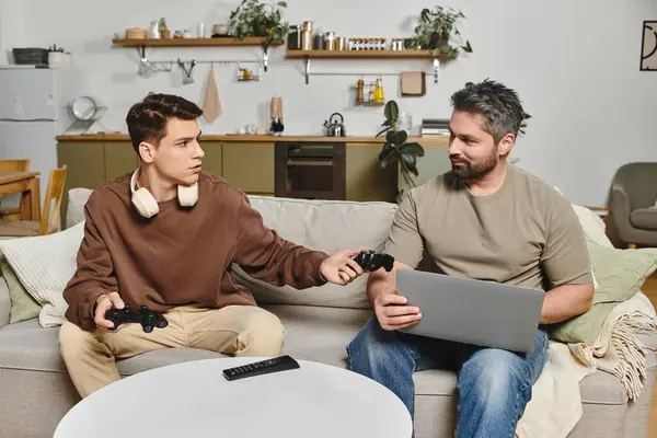 Two brothers share joyful moments while playing video games together at home. — Stock Photo