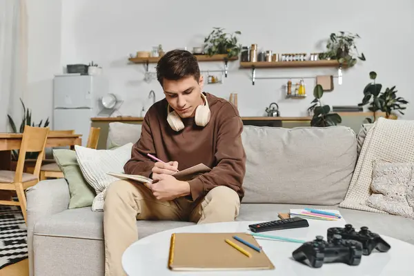 In a cozy living room, a young adult relaxes and writes in their journal. — Stock Photo