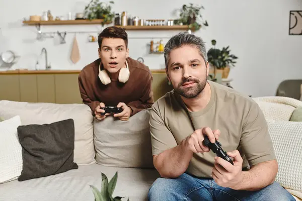 Two brothers share laughter and excitement while playing video games in a homely setting. — Stock Photo