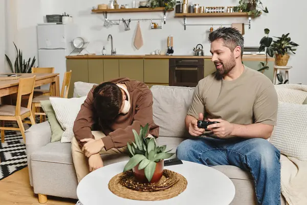 Two brothers unwind in a cozy living room, playing video games and enjoying each others company — Stock Photo