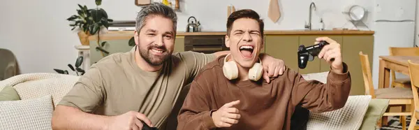 Due fratelli a casa condividono una risata mentre giocano insieme in un accogliente spazio abitativo pieno di calore. — Foto stock