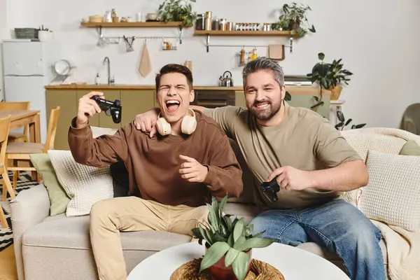 Due fratelli celebrano la loro vittoria di gioco a casa, circondati da un arredamento caldo e invitante. — Foto stock