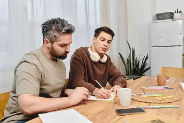 Two brothers engage in a creative activity at home, surrounded by colorful supplies and warmth. — Stock Photo