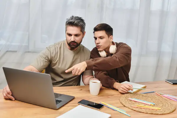 Two brothers engage in an intense brainstorming session while exploring ideas on a laptop. — Stock Photo