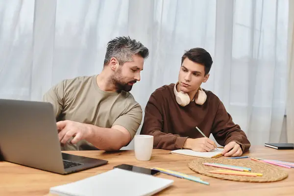 Two brothers engage in a productive learning session at home, sharing knowledge and notes. — Stock Photo