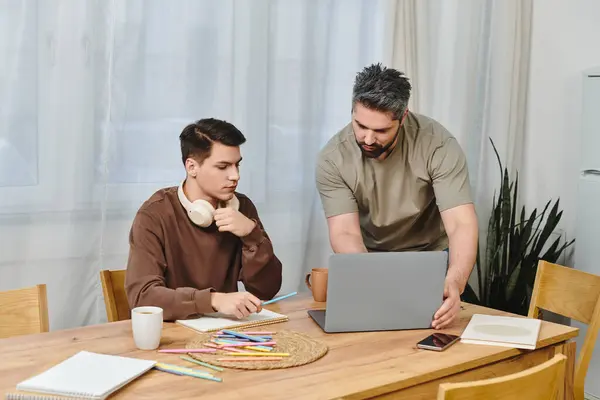 Two brothers engage in a collaborative effort at a cozy kitchen table, fostering creativity. — Stock Photo