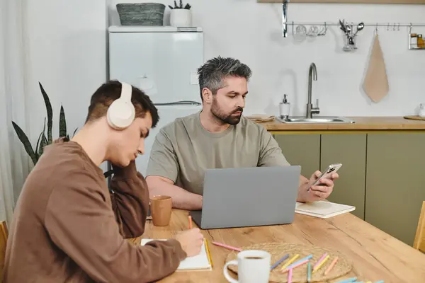 Two brothers enjoy various activities at a cozy dining table in a warm setting. — Stock Photo