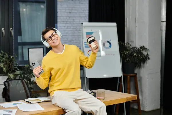 Celebrating the beginning of a new job, a young man relaxes in a bright office environment. — Stock Photo