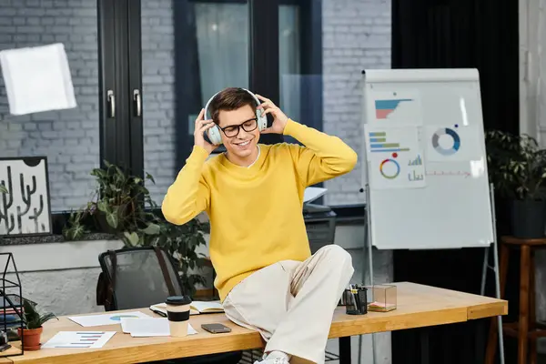 New employee enjoys a moment of relaxation while listening to music at his desk during onboarding. — Stock Photo