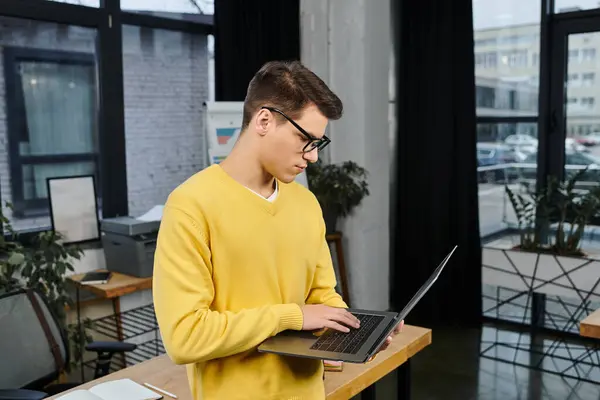 New employee engaged with their laptop in a bright office, eagerly starting their new job tasks. — Stock Photo
