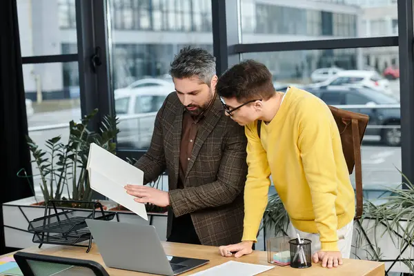 Two new hires onboard, reviewing documents in a bright and welcoming workspace. — Stock Photo