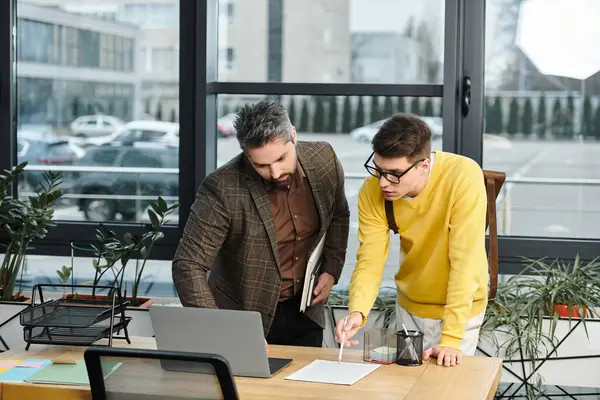 Two colleagues collaborate on a project during onboarding in a bright, contemporary office space. — Stock Photo