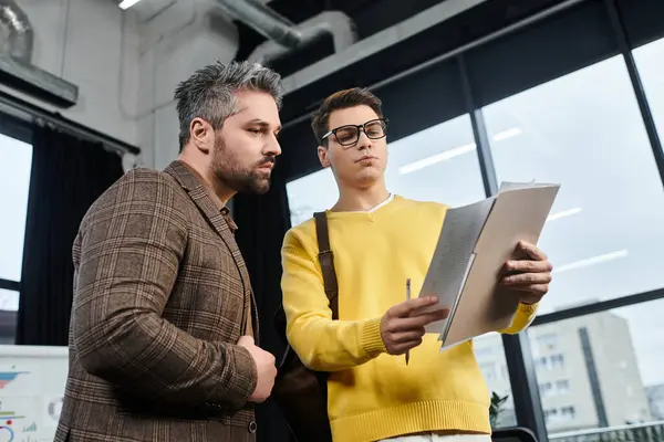 Deux collègues en tenue formelle examinent les documents lors de l'embarquement dans un bureau moderne. — Photo de stock