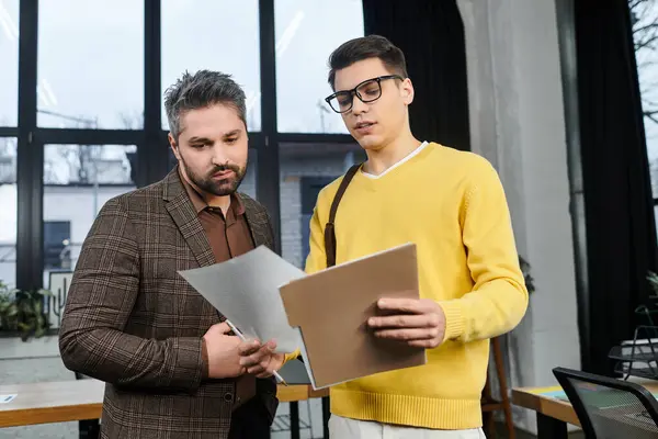 Two professionals discuss essential documents in a vibrant office on the first day of work. — Fotografia de Stock