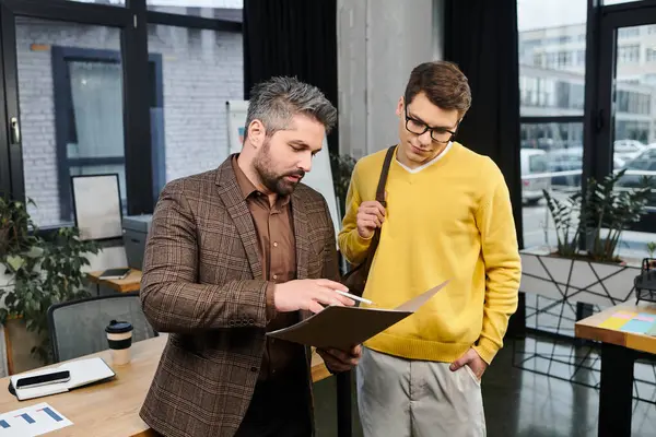 Two professionals in a contemporary office discussing onboarding details with enthusiasm. — Stock Photo