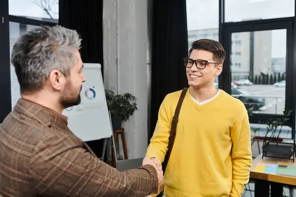 New employee excitedly greets a coworker on their first day in a lively office. — Stockfoto