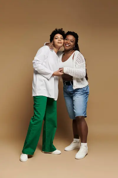Zwei Frauen umarmen sich herzlich und zelebrieren ihre Liebe in stilvollen, lebendigen Outfits. — Stockfoto