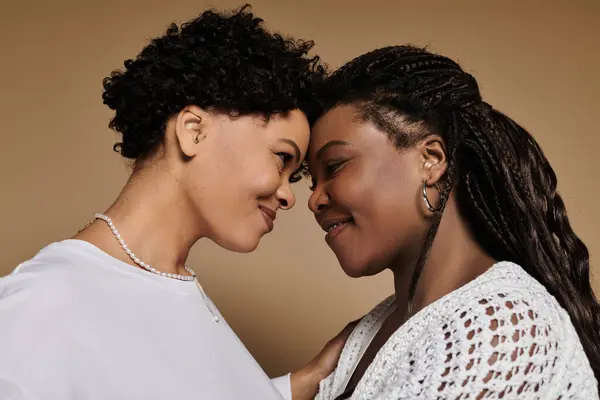 Dos mujeres elegantes comparten una mirada amorosa, irradiando alegría y conexión. — Stock Photo