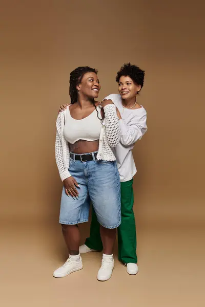 Two fashionable women showcase their vibrant style while enjoying each others company. — Stock Photo