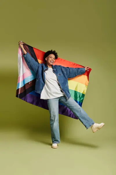 Fashionable individual showcasing pride flag on green backdrop. — Stock Photo