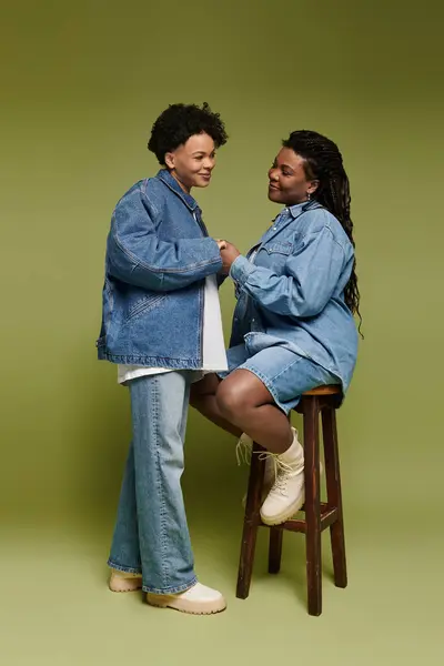 A stylish lesbian couple hugs warmly, radiating love and fashion in denim. — Stock Photo