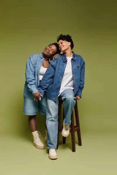 Stylish couple holds hands while sharing a warm embrace in a chic, intimate moment. — Stock Photo