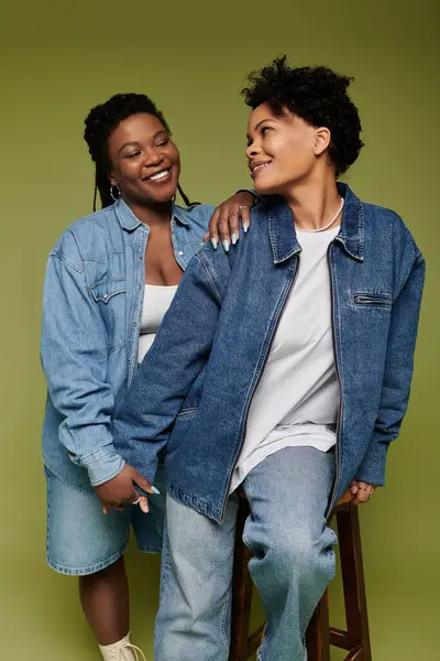 Élégant couple lesbien bénéficie d'un moment chaleureux et aimant tout habillé en denim à la mode. — Photo de stock