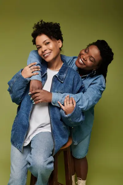 Two fashionable women share a joyful moment, radiating love and confidence in trendy denim. — Fotografia de Stock