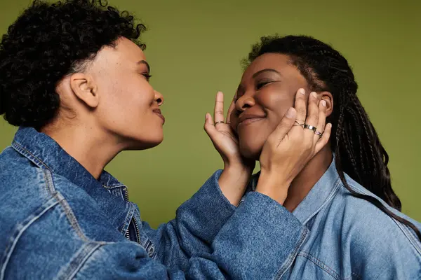 Zwei liebevolle Frauen umarmen sich freudig und präsentieren ihre modischen Outfits und ihre lebendige Verbindung. — Stockfoto