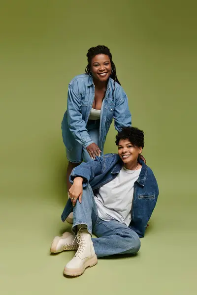 Two stylish women share a joyful moment, radiating love against a vibrant backdrop. — Stock Photo
