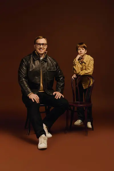 Joyful father and son pose in a casual studio environment, smiling and enjoying their time together. — Stock Photo