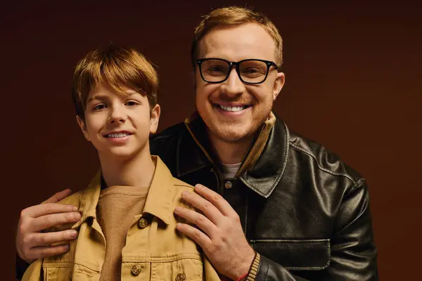 Father and son share a warm smile together while dressed in stylish casual attire. — Stock Photo