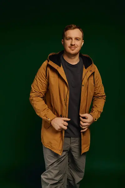 A stylish man in casual wear poses confidently against a striking backdrop. — Stock Photo