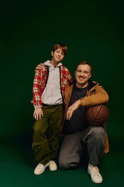 A father and his son share smiles while dressed in matching casual outfits, showcasing family love. — Stock Photo