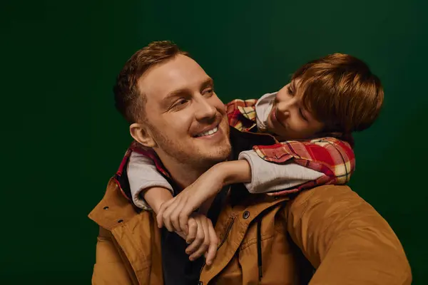 A father and son share laughter in a playful studio, showcasing their bond. — Stock Photo