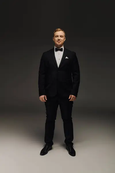 A handsome man dressed in formal attire stands poised, exuding sophistication and charm. — Stock Photo