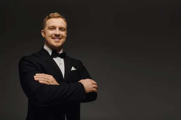 A stylish man showcases his elegance with a bow tie, standing confidently in a studio. — Stock Photo