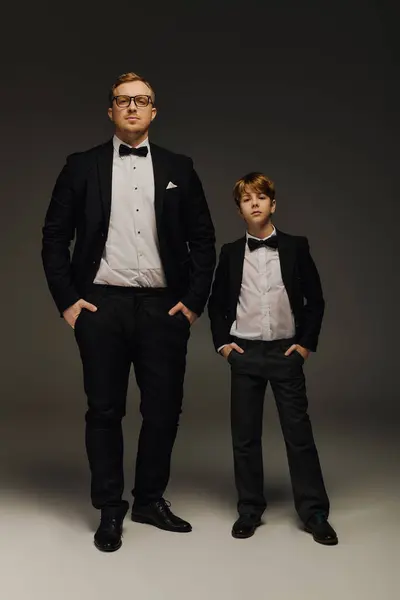 A dapper father and son stand confidently side by side in formal attire, radiating charm. — Stock Photo