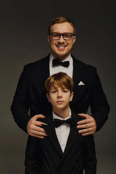 Two dapper individuals dressed in matching tuxedos pose confidently, showcasing their bond. — Stock Photo