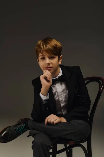 A young boy showcases his fashion sense wearing a dapper suit complete with a bow tie in a studio. — Stock Photo