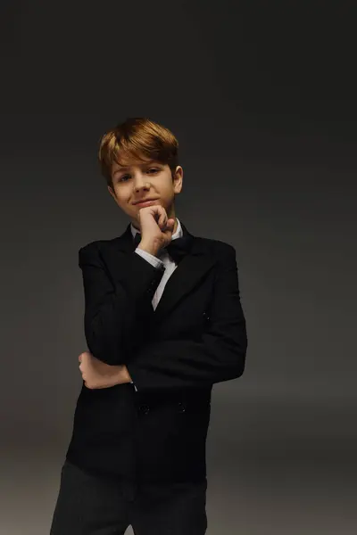 A preteen boy poses confidently in a chic tuxedo with a bow tie, showcasing children fashion. — Stock Photo