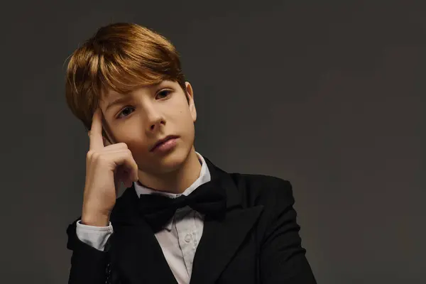 A poised preteen boy in a stylish tuxedo and bow tie exudes charm and elegance. — Stock Photo