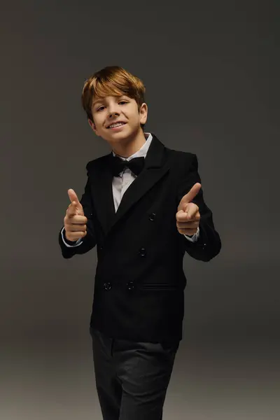 Stylish preteen boy poses confidently in a chic outfit complete with a bow tie, exuding charm. — Stock Photo