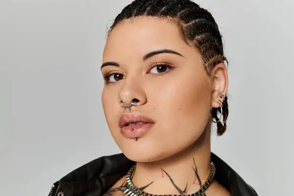 A young woman with braided hair and distinctive piercings exudes confidence in her fashion choices. — Stock Photo