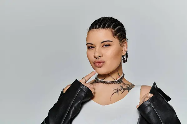Young woman showcases her fashion sense with striking tattoos and stylish attire in an urban space. — Stock Photo
