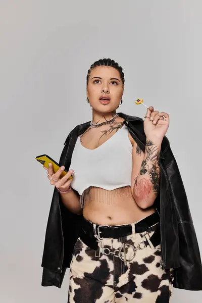 Junge Frau mit Zöpfen präsentiert ihren einzigartigen Stil in einem schicken Outfit, während sie einen Lutscher hält. — Stockfoto